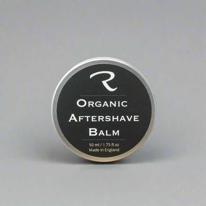 Organic aftershave balm tin on a wooden surface with a white background