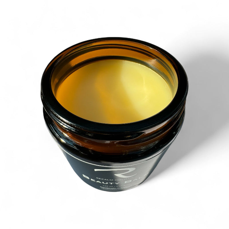 Jar of yellow cream with a visible brand logo on a white background