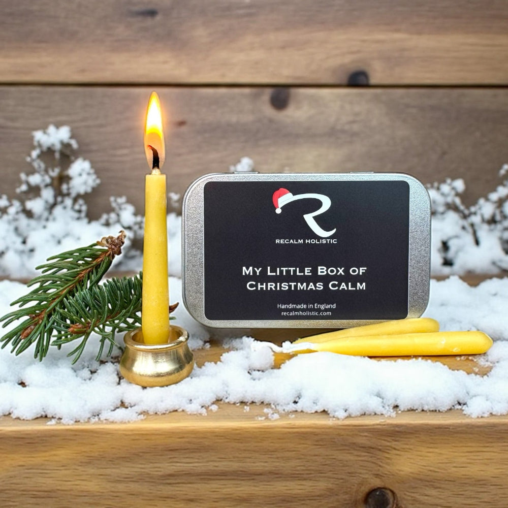 Recalm Holistic 'My Little Box of Christmas Calm' product with a lit candle and snowy background