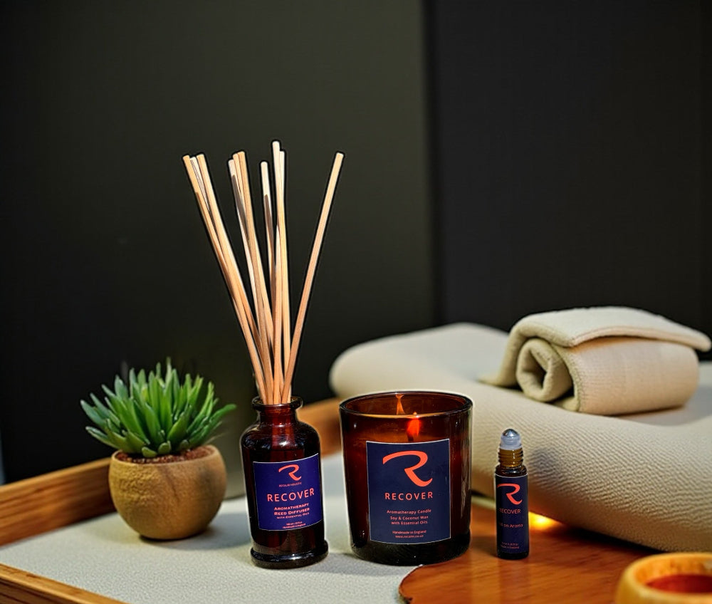 Recover diffuser, candle, and roll on aroma for pulse points with eucalyptus, rosemary and pine ssential oills, bottle on a tray with a plant and towel in the background, ritual for self care