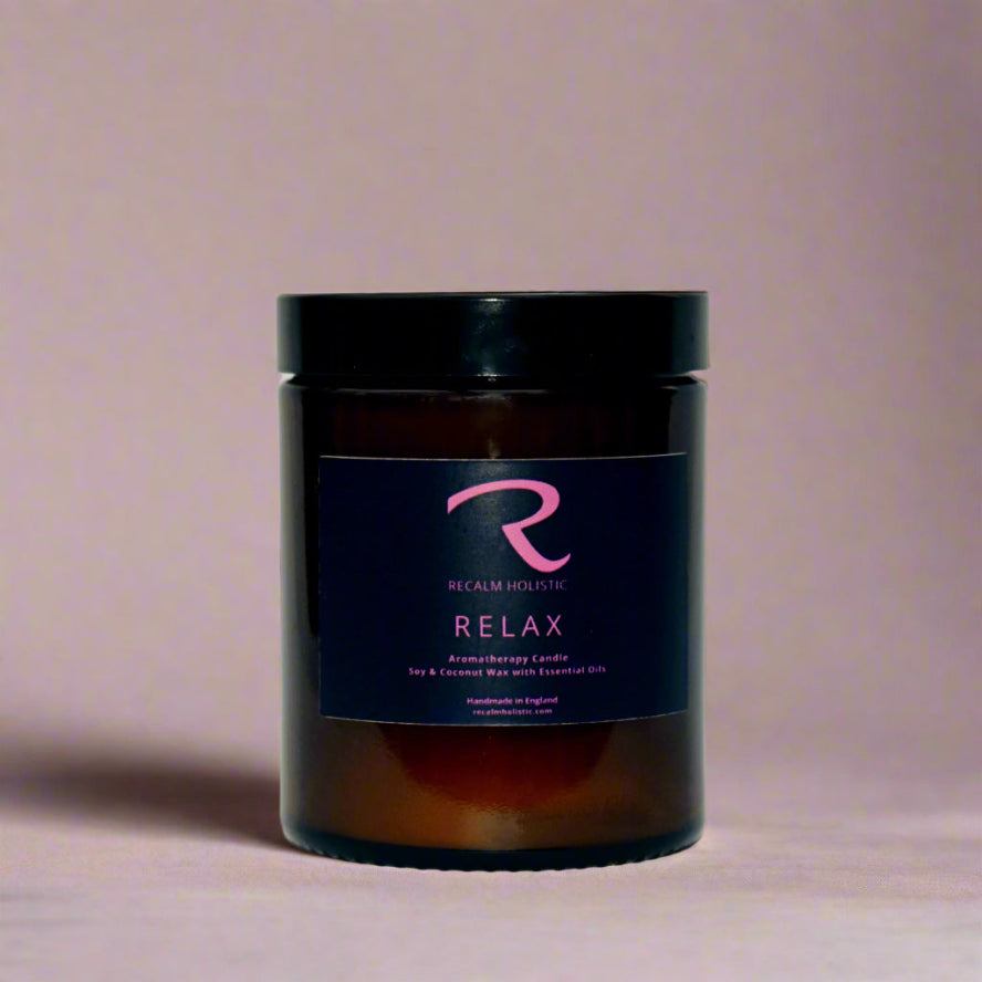 Aromatherapy candle jar labeled 'Relax' with a visible brand logo on a beige background