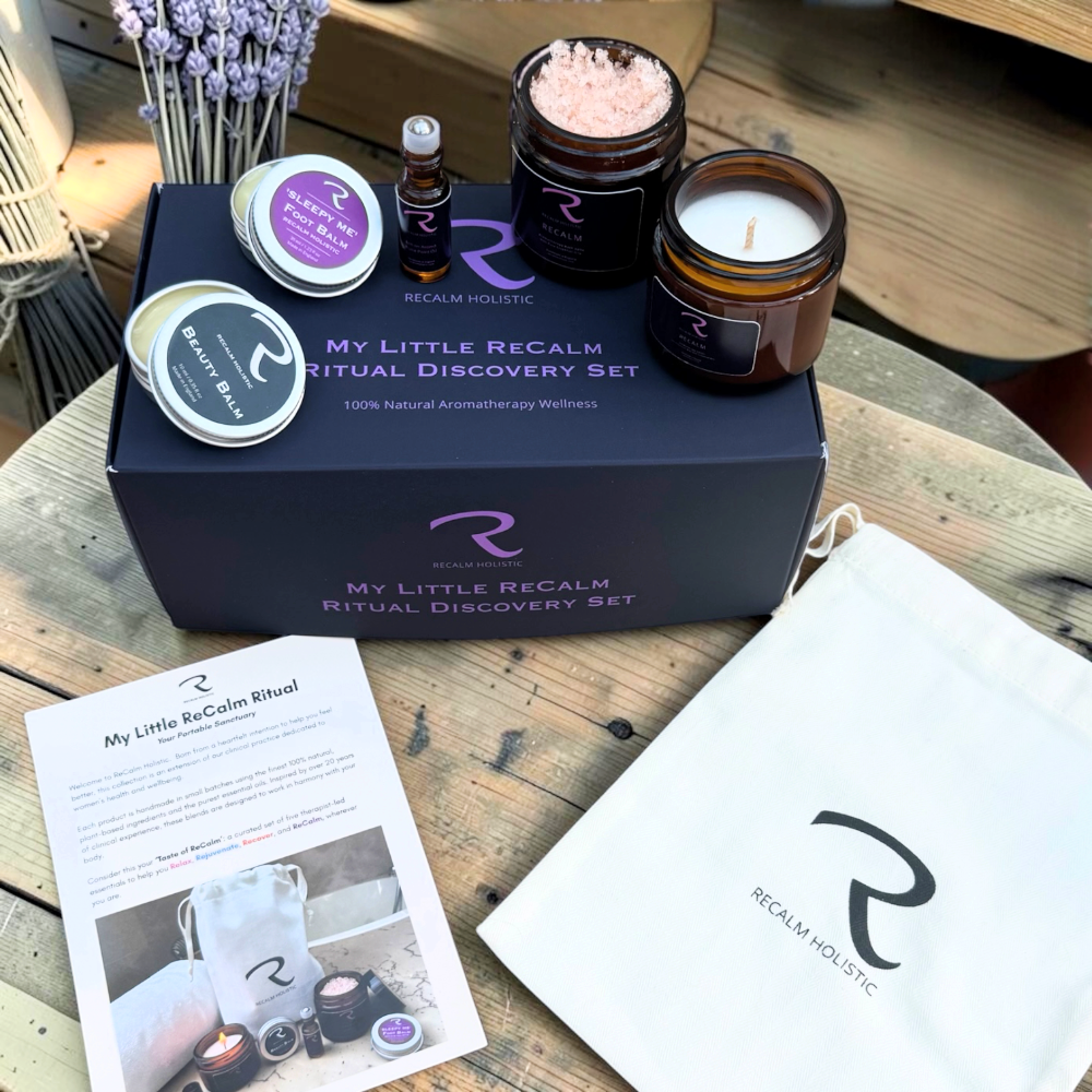 A Recalm Holistic 'My Little Recalm Ritual Discovery Set' arranged on a rustic wooden table. The set includes everything you need for self-care rejuvenation in the comfort of your home, 100 Natural ingredients, Aromatherapy Gift Set includes Aromatherapy Candle, Botanical Bath Salts, Pulse Points, ReCalm Beauty Balm, ReCalm Sleepy Me Balm in Miniature form.