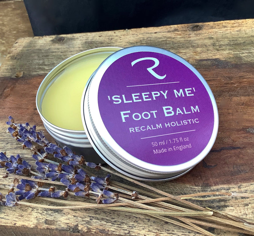 'Sleepy Me' Foot Balm container on a wooden surface with lavender flowers