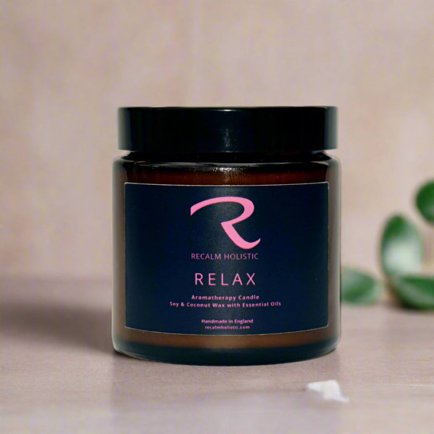 Aromatherapy candle jar with 'Recalm Holistic' label on a white background