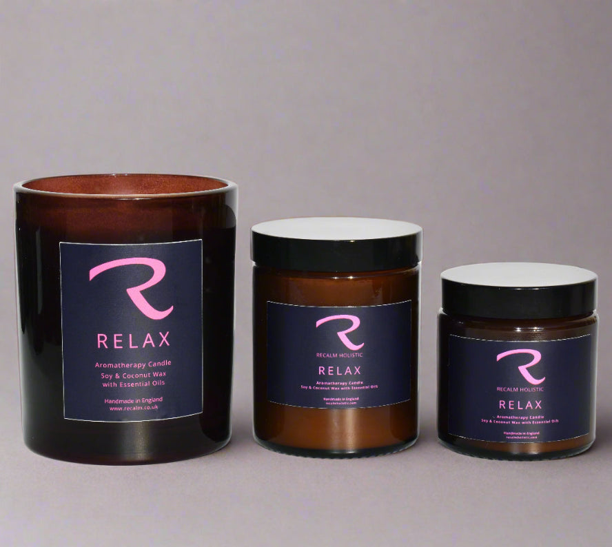 Three candles with 'Relax' branding on a gray background