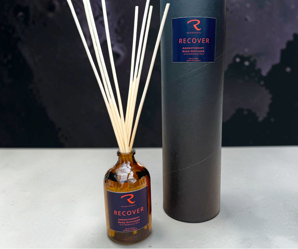 Recover reed diffuser in amber glass apothecary bottle with cylinder box branded Recalm Holistic with reeds.