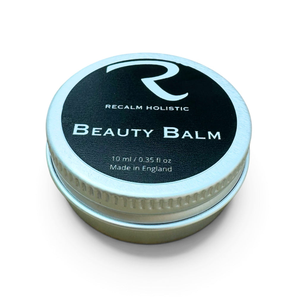 The mini 15ml travel tin of ReCalm Beauty Balm, a portable skin barrier repair balm perfect for on-the-go hydration and quick dry spot touch-ups