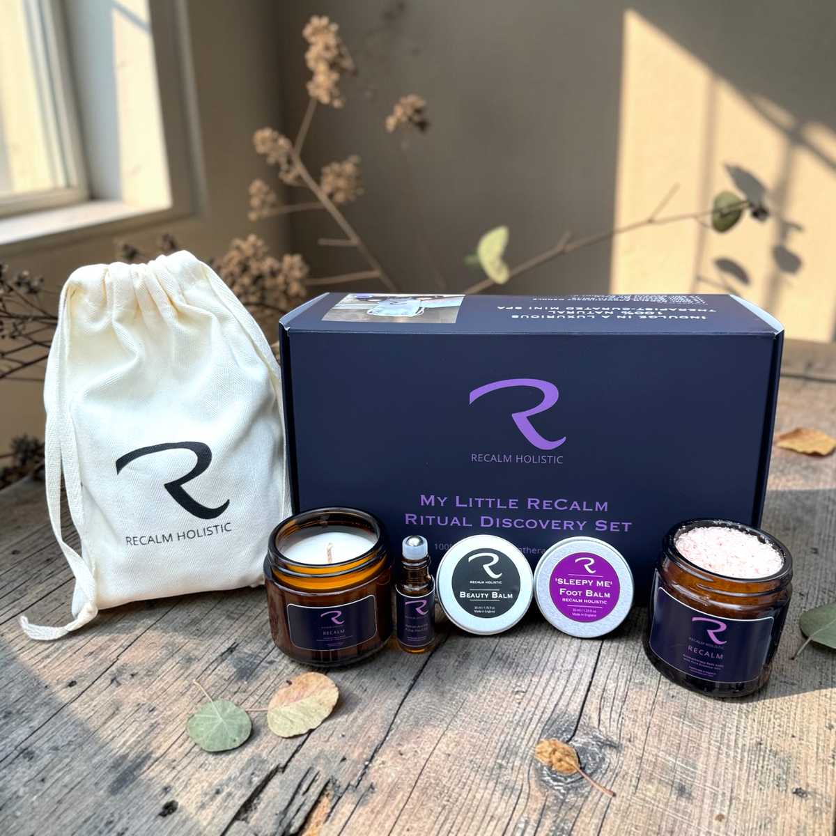 ReCalm Holistic autumn wellness collection featuring My Little ReCalm Ritual 5-miniature discovery set in a herringbone cotton pouch, natural skin barrier beauty balms, and aromatherapy bath salts in a cosy countryside studio setting