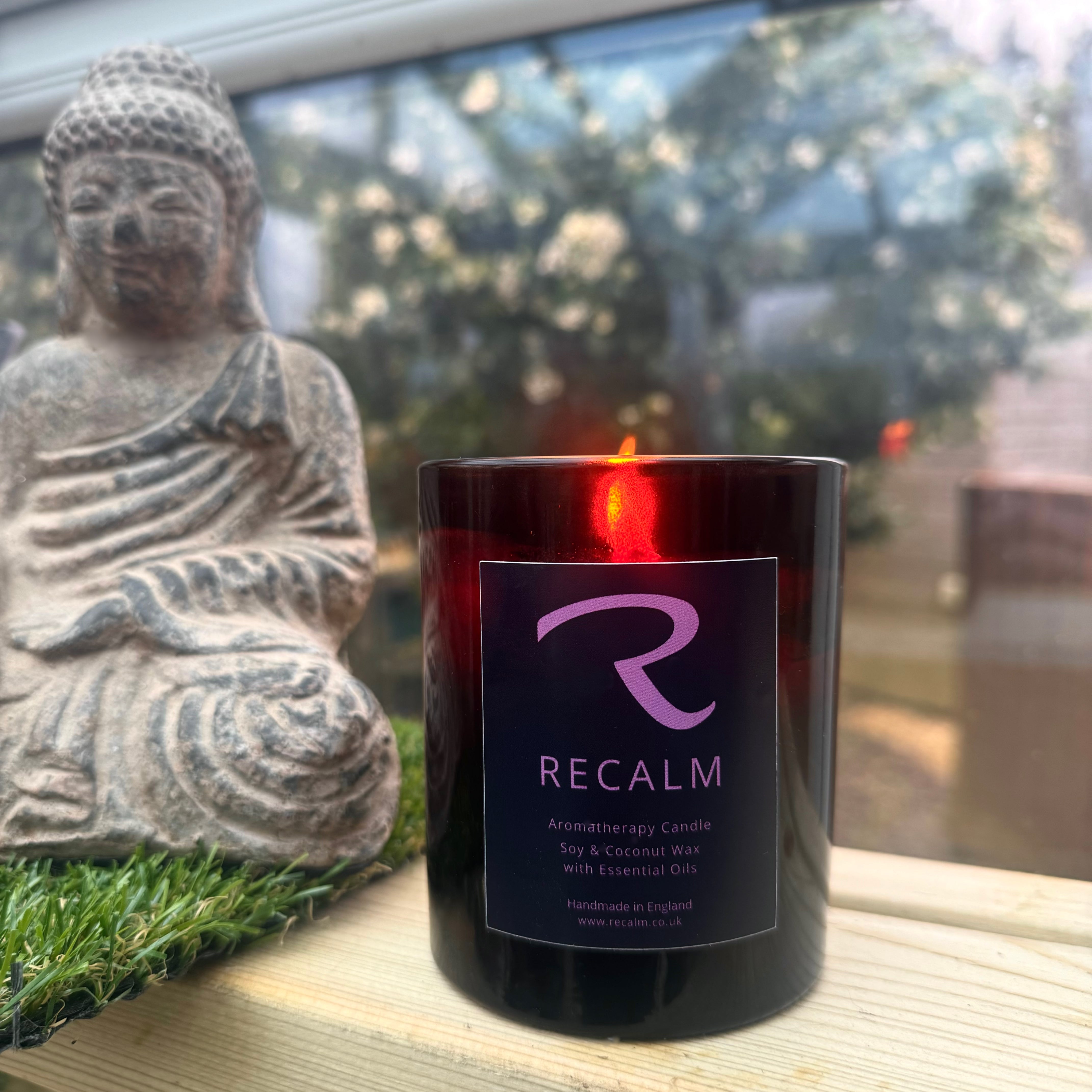 Hand-poured natural aromatherapy candles in amber glass jars on a minimalist surface, showcasing clean vegan soy and coconut wax blends