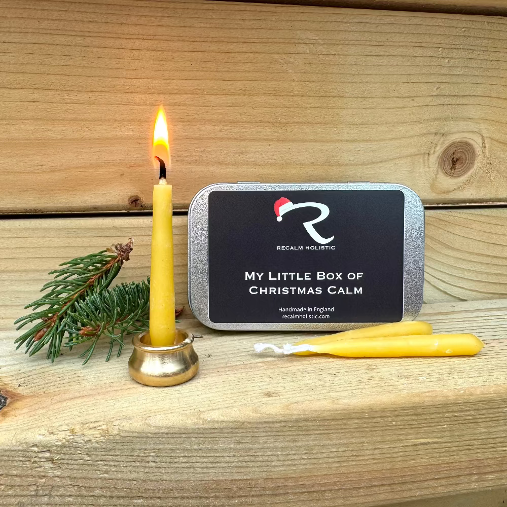 My Little Box of Christmas Calm product with a lit candle and pine branch on wooden surface