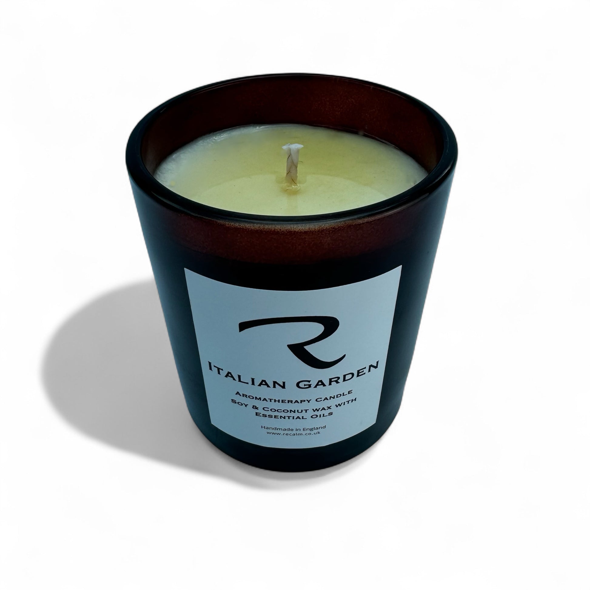 Candle in a black container with a label on a white background