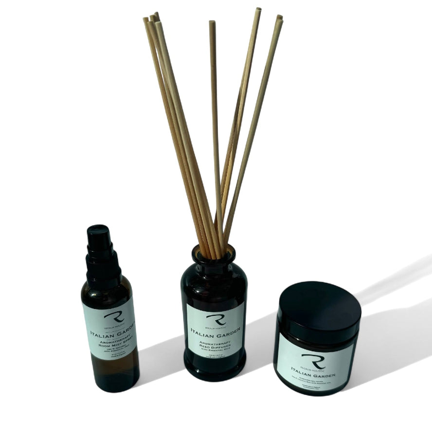 Set of Italian Garden diffuser bottles with reeds and a aromatherapy candle on a white background