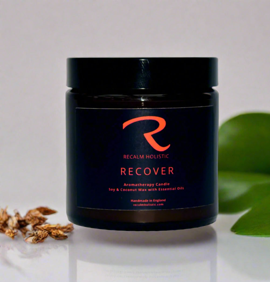 Aromatherapy candle jar labeled 'Recover' by Recalm Holistic on a neutral background.