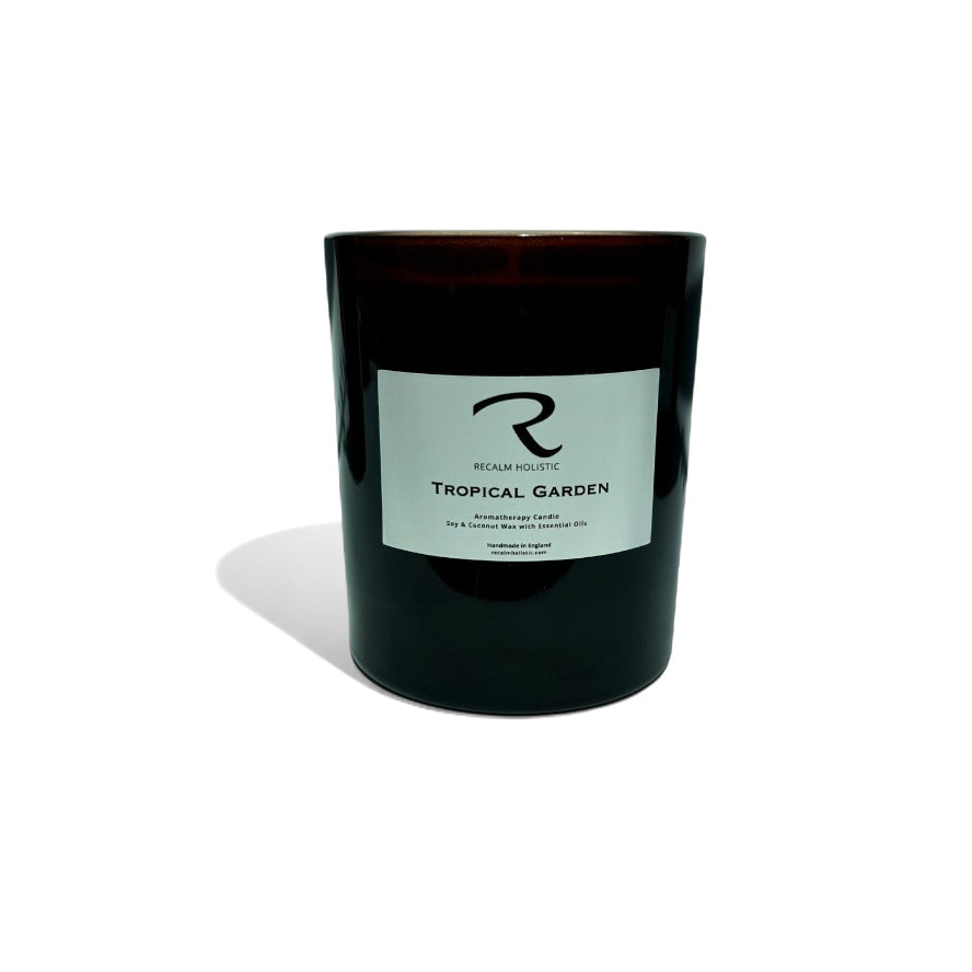 Amber candle with a label on a white background with Tropical Garden on the label