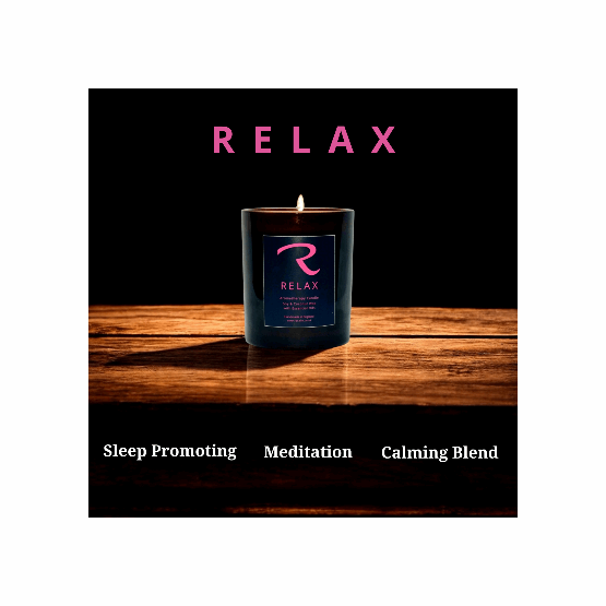 Candle with 'RELAX' branding on a wooden surface and black background