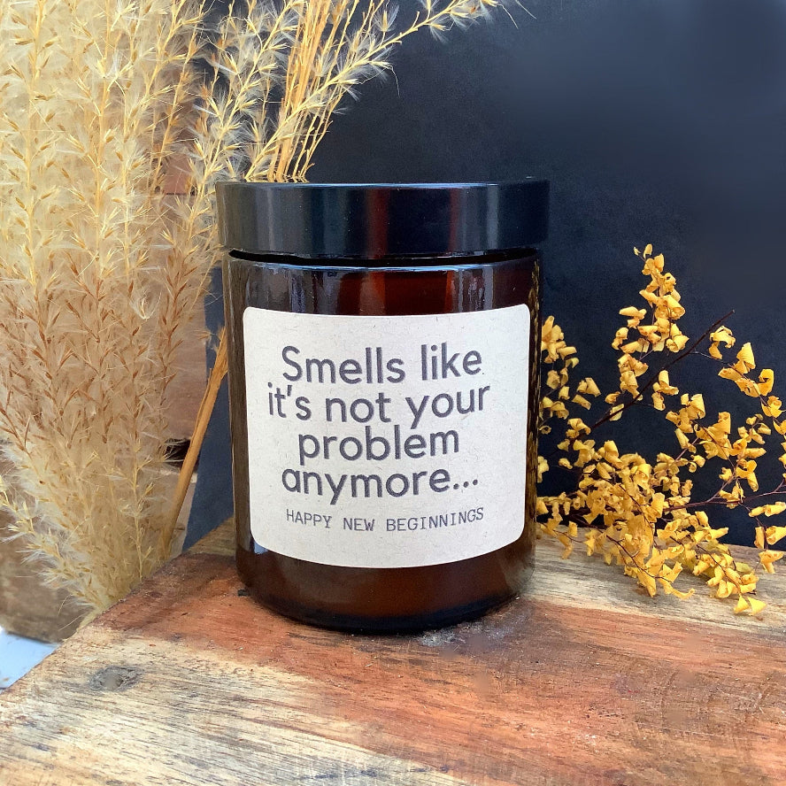 Candle jar with a label reading 'Smells like it's not your problem anymore.