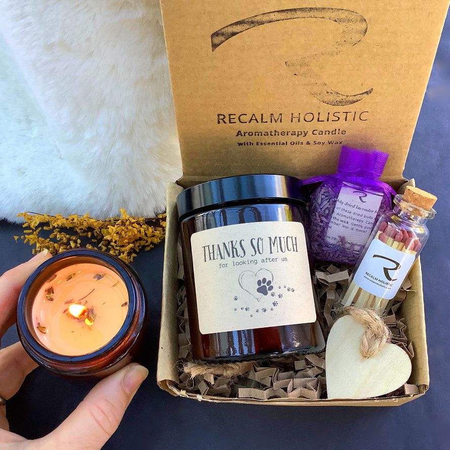 Gift set with candles and essential oils from Recalm Holistic on a dark surface.
