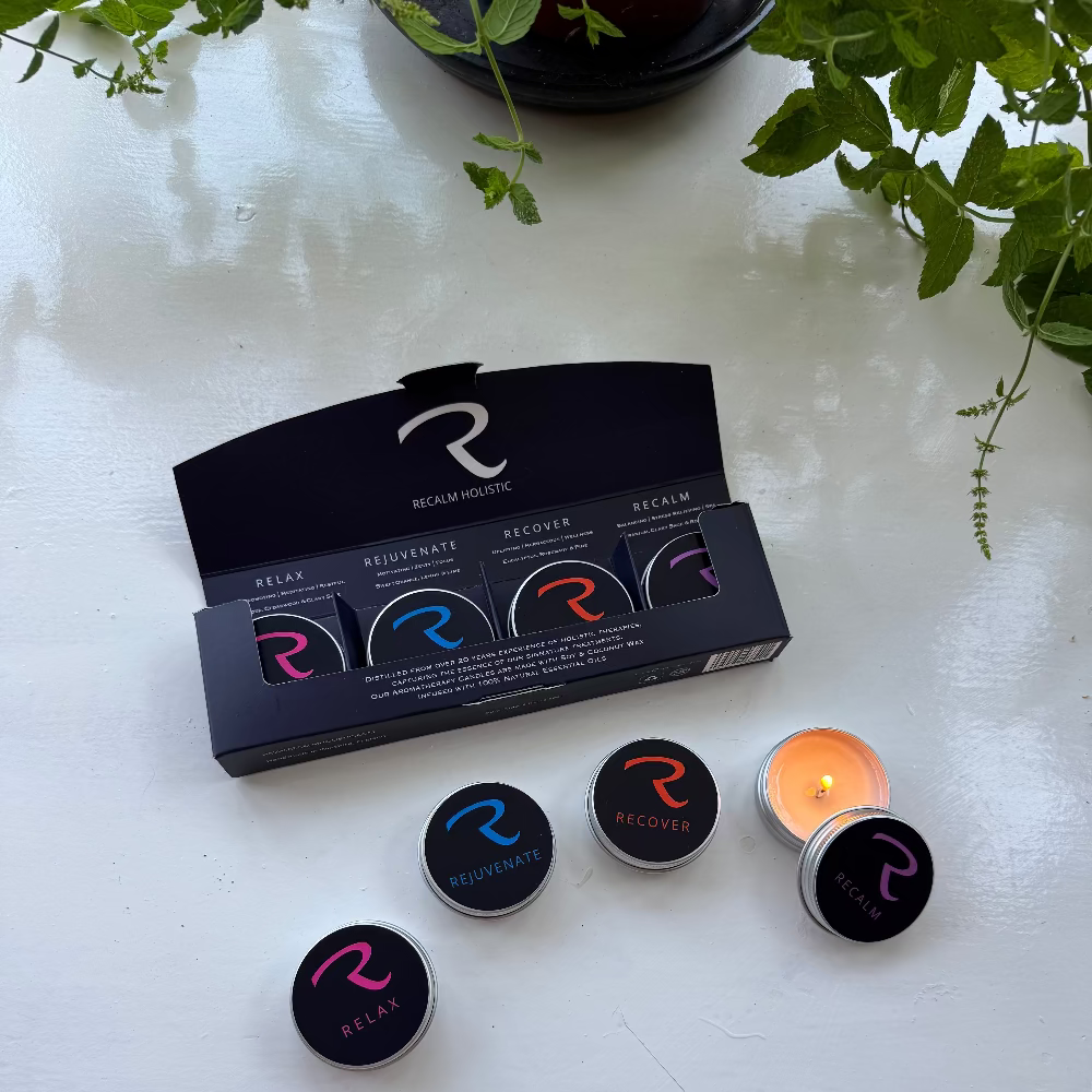 The ReCalm Holistic 4-Piece Aromatherapy Candle Discovery Set, beautifully featured in a stunning gift presentation box. Includes four hand-poured, natural soy and coconut wax tealight samples infused with pure essential oils—Relax (Lavender & Clary Sage), Rejuvenate (Citrus Blend), Recover (Eucalyptus & Pine), and ReCalm (Signature Spa Blend). Handcrafted in Wiltshire, UK.