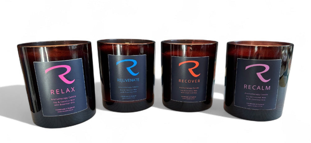 Four 300ml signature aromatherapy spa candles by Recalm Holistic, Relax, Rejuvenate, Recover, and Recalm, arranged on a white studio background